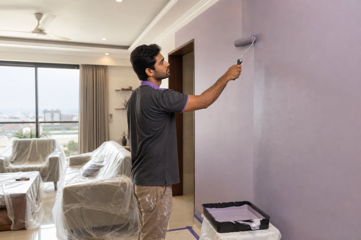 Professional painter finishing a lavender wall in a Bhopal home